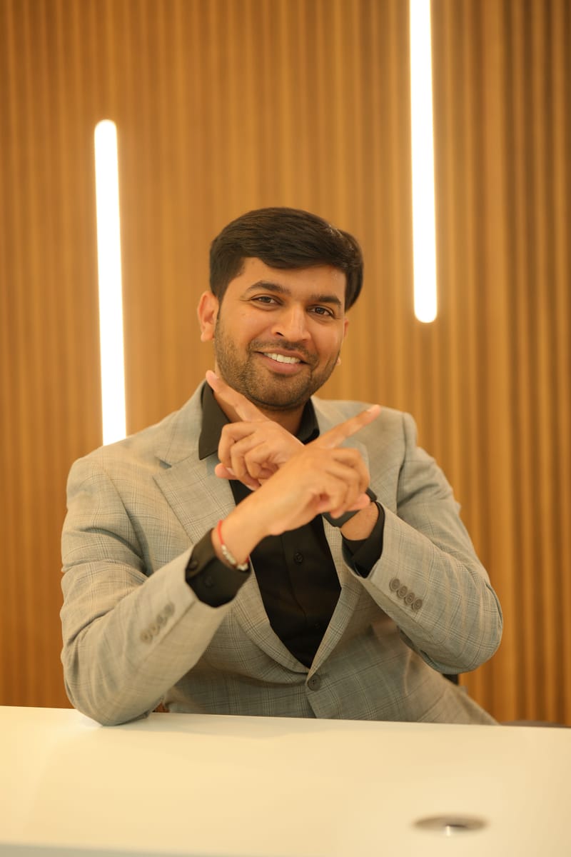 Kaushik Patel smiling with his arms crossed in an X